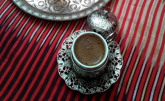 piaxabay / Amuljar 은으로 장식된 컵에 담긴 모카커피가 검정색 줄무늬 붉은 천 테이블 보 위에 놓여 있다.